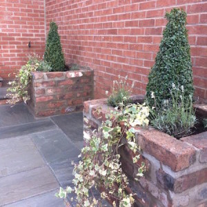 Reclaimed brick planters and grey sandstone paving